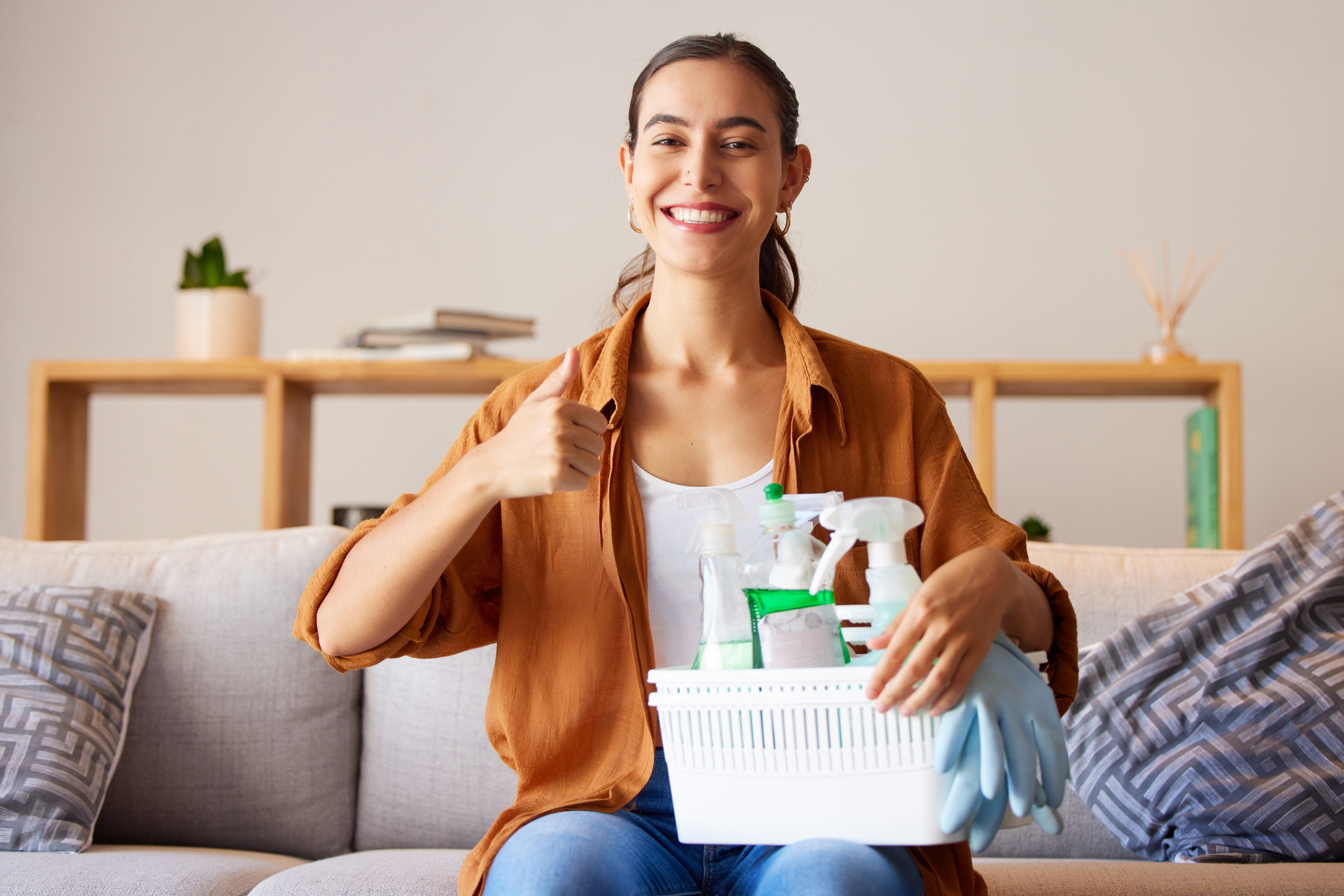 Woman, portrait and thumbs up for home, cleaning and housekeeping with container of product tools.